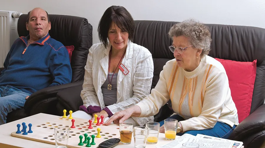 Pflegerin spielt mit älterer Dame Mensch Ärgere Dich Nicht. Foto: Stefan Ernst.